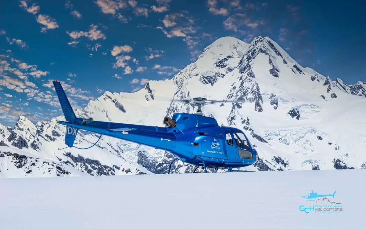 A helicopter flying over the blue icefall of Franz Josef Glacier
