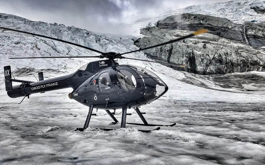 A helicopter parked on a snowfield high in the Southern Alps